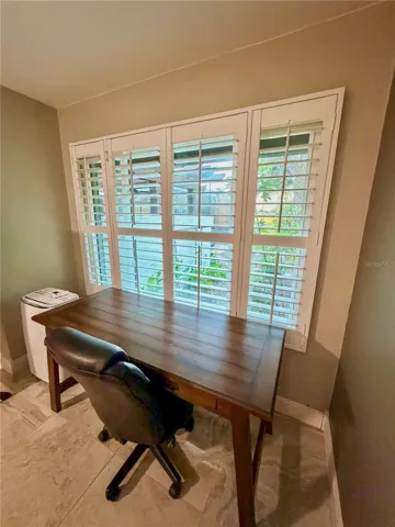 Windows in master bedroom overlooking backyard and green