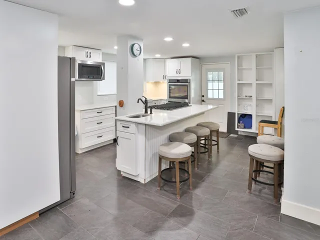 Kitchen with tiled floors and quartz countertops.