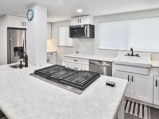 Gas stove in kitchen and quartz counter tops.