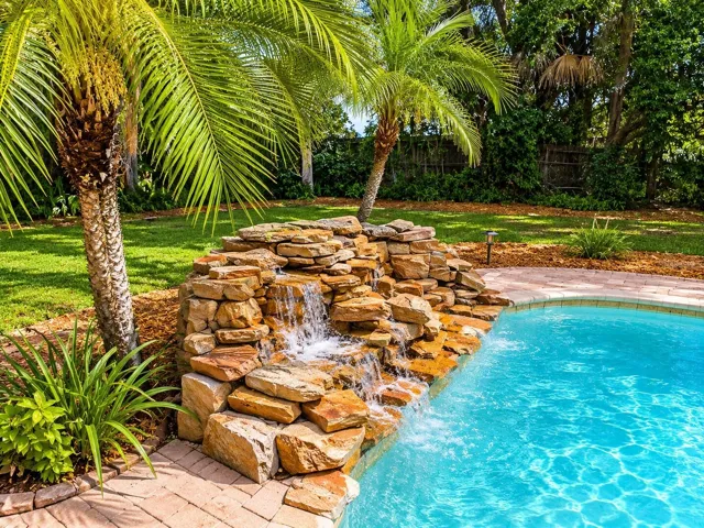 Tropical backyard with rock waterfall