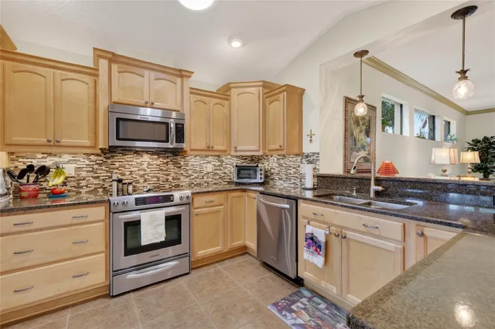 Beautiful kitchen! With Granite, vaulted ceiling, tile backsplash and gleaming ss appliances