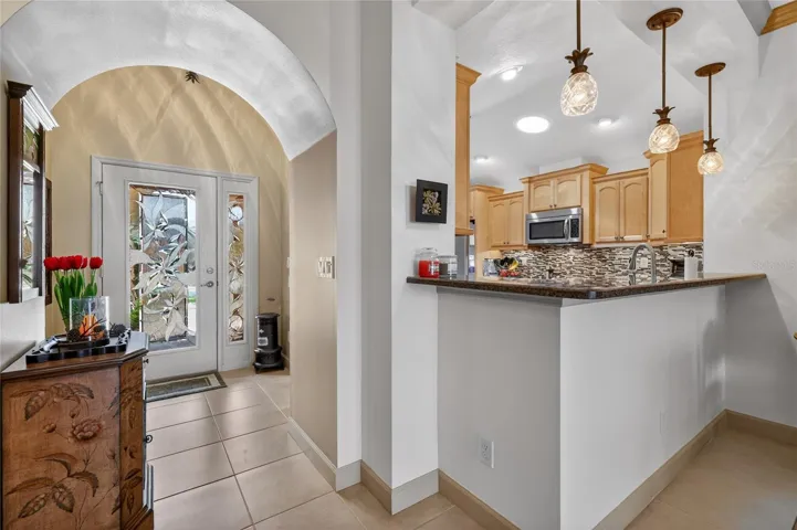 Foyer from living/dining room. Kitchen with Granite-topped breakfast bar.