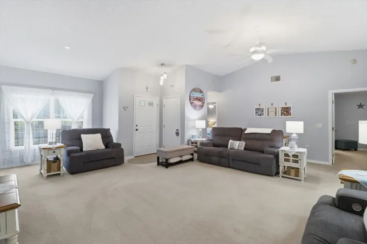 Living Room w/ Vaulted Ceiling & Slider to the Enclosed Sunroom ...Neutral Colors Throughout