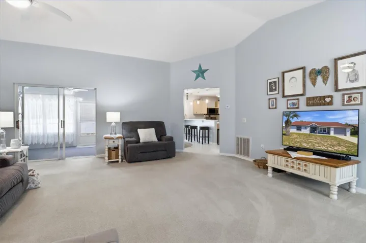 Living Room w/ Vaulted Ceiling & Slider to the Enclosed Sunroom ...Neutral Colors Throughout
