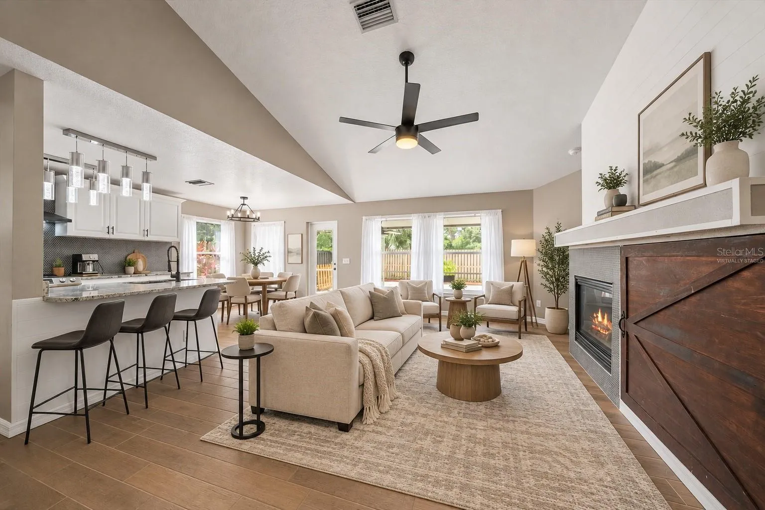 Virtually staged living room with breakfast bar seating in the kitchen