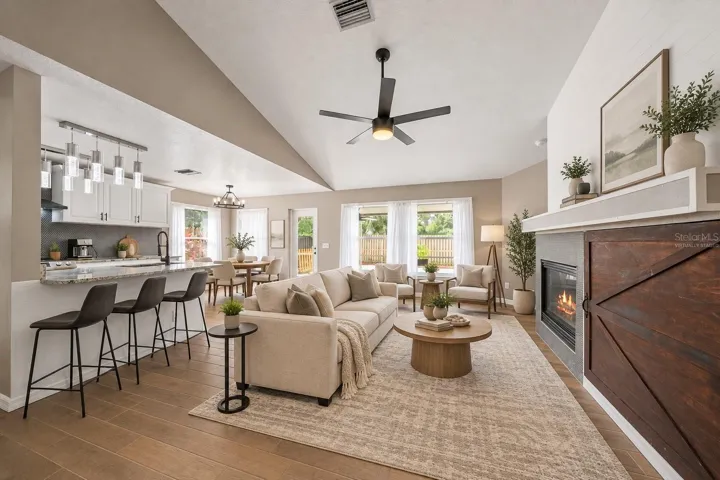 Virtually staged living room with breakfast bar seating in the kitchen