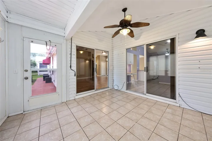 ENCLOSED LANAI with exit to PERGOLA covered patio (L). Note: Two sets of sliding glass doors to LIVING ROOM (center) and BREAKFAST ROOM (R).