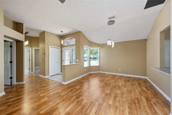 FRONT DOOR, FOYER with coat closet & half wall, and DINING ROOM (located on R) - Note the matching light fixtures in the DINING ROOM, FOYER and HALLWAY.