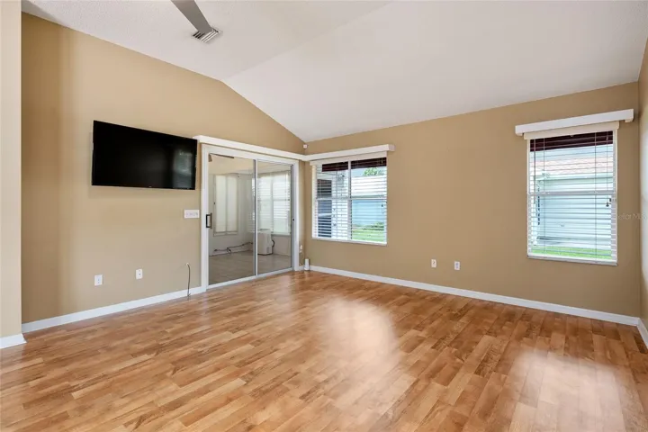 LIVING ROOM with WOOD LAMINATE flooring - SLIDING GLASS DOORS lead to the ENCLOSED LANAI