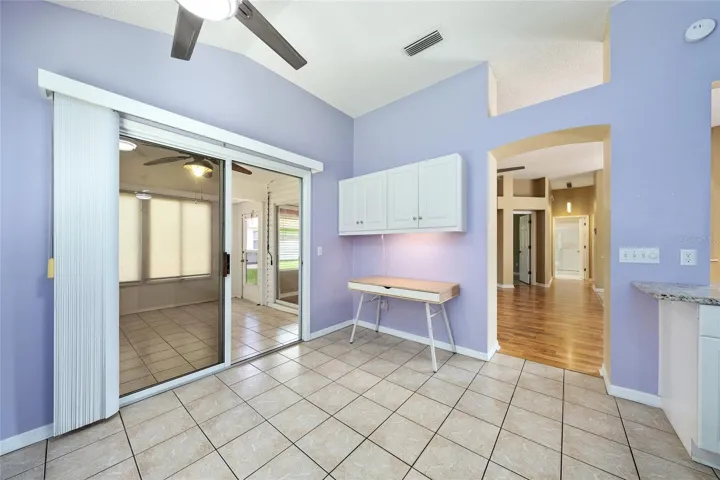 BREAKFAST ROOM in forefront, ENCLOSED LANAI (L back) and ARCHED ENTRYWAY with plant shelf (R)