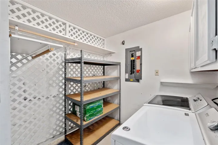 LAUNDRY AREA with storage racks and overhead storage cabinets.