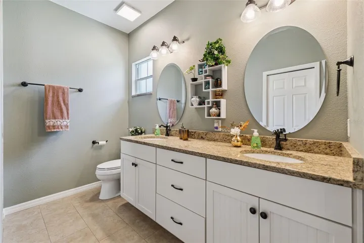 Primary bath includes custom cabinetry with dual sinks, soft close hinges and granite countertops