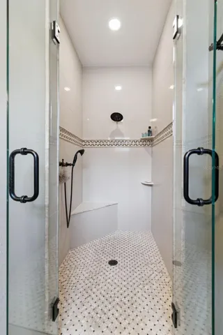 Large seated walk-in shower with French glass doors