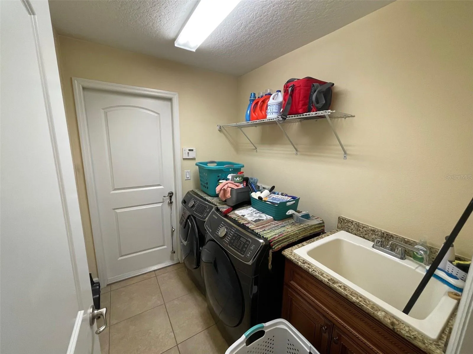 inside laundry room with sink, leads to garage