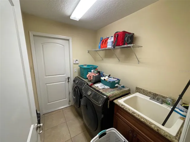 inside laundry room with sink, leads to garage