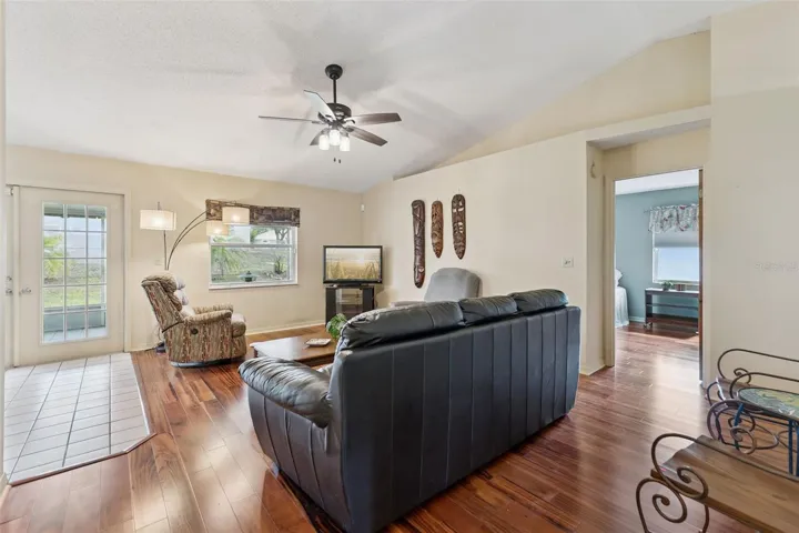 Spacious living room features tigerwood flooring and decorative planter shelf
