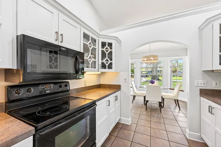 The Kitchen showcases BEAUTIFULLY UPDATED SOLID WOOD WHITE CABINETRY, including select glass-front display cabinets.