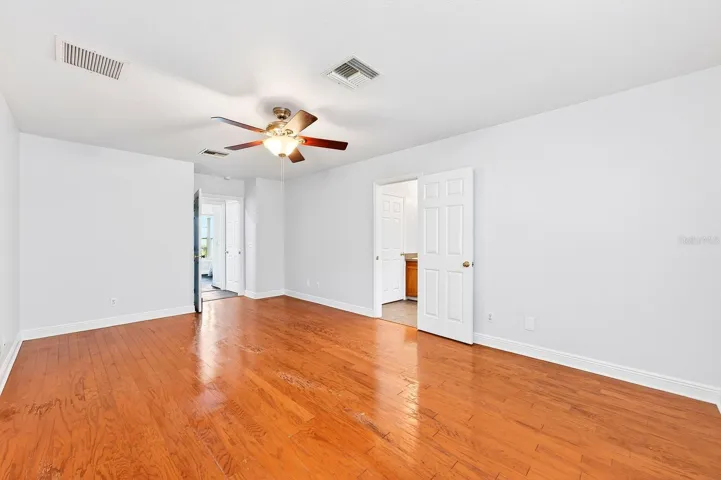 The generous Primary Suite serves as a relaxing retreat, featuring HARDWOOD FLOORING, a sleek ceiling fan, peaceful backyard views, a walk-in closet, and an EN SUITE BATH.