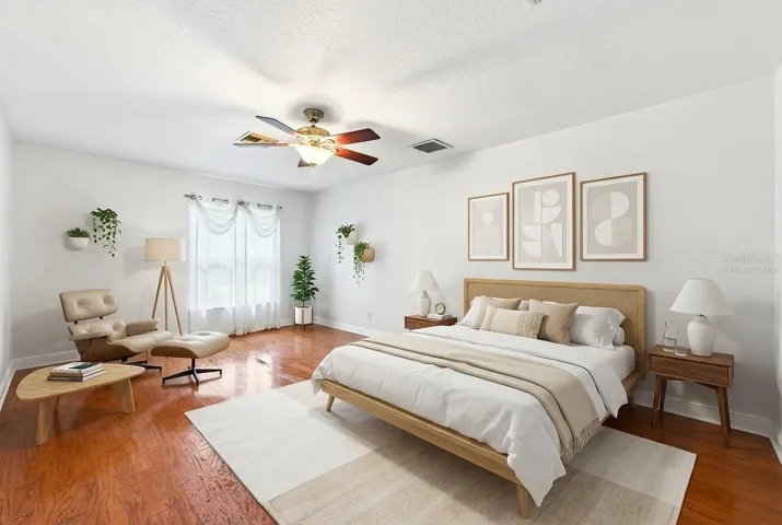 The generous Primary Suite serves as a relaxing retreat, featuring HARDWOOD FLOORING, a sleek ceiling fan, peaceful backyard views, a walk-in closet, and an EN SUITE BATH. Virtually Staged