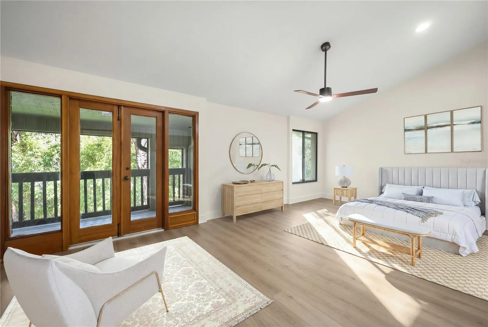 virtually staged primary bedroom with french doors to private balcony