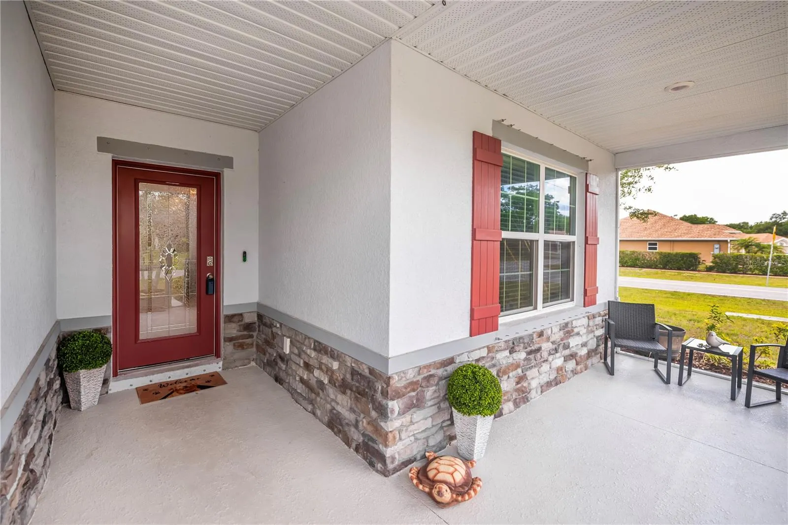 Stone Accented Screened Front Entryway with Leaded Glass Door.