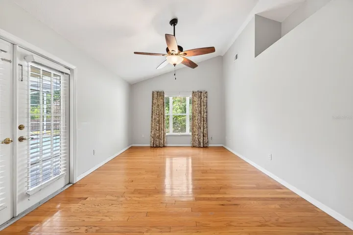 The Family Room features RICH HARDWOOD FLOORING and French doors that open to the outdoor patio and pool area, creating seamless indoor-outdoor living.