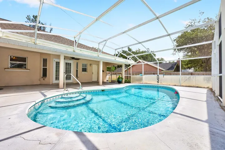 The covered patio and SPARKLING IN-GROUND POOL are all enclosed within a screened lanai, offering the perfect setting for relaxing, entertaining, or enjoying Florida’s year-round sunshine.