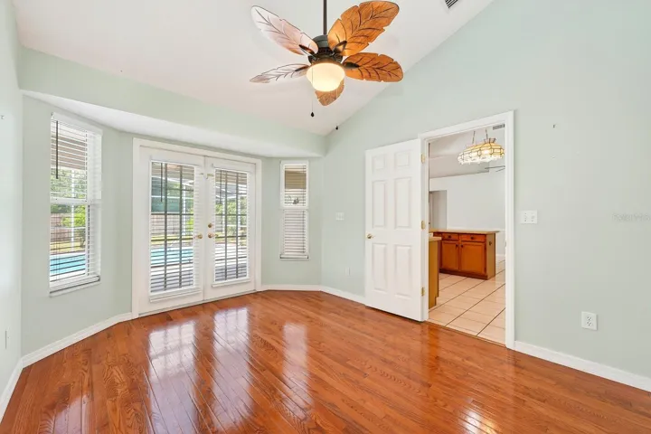 A VERSATILE BONUS ROOM with hardwood floors and French doors to the lanai offers ENDLESS POSSIBILITIES as a 4th Bedroom, formal Dining Room, Office, or flex space.