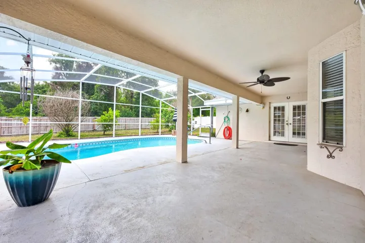 The covered patio and SPARKLING IN-GROUND POOL are all enclosed within a screened lanai, offering the perfect setting for relaxing, entertaining, or enjoying Florida’s year-round sunshine.