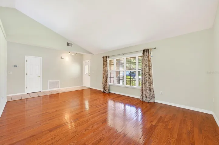 Step inside to a welcoming separate Living Room featuring HARDWOOD FLOORING and SOARING VAULTED CEILINGS, creating a bright and elegant first impression.