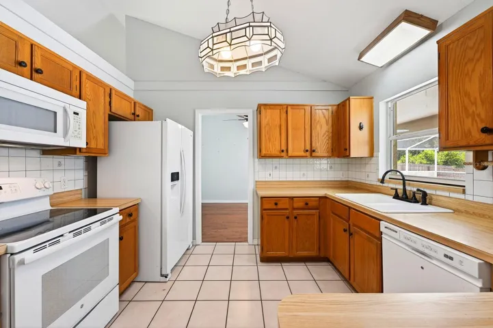 The open Kitchen provides plenty of solid wood cabinets, beautiful butcher block countertops and a stylish tile backsplash.