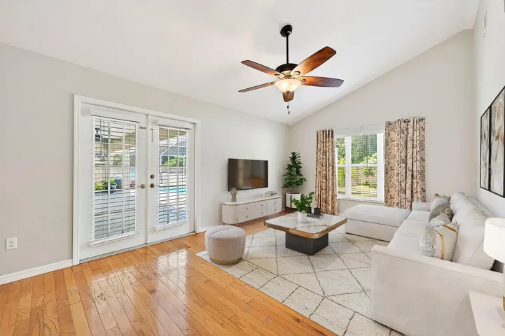 The Family Room features RICH HARDWOOD FLOORING and French doors that open to the outdoor patio and pool area, creating seamless indoor-outdoor living. Virtually Staged