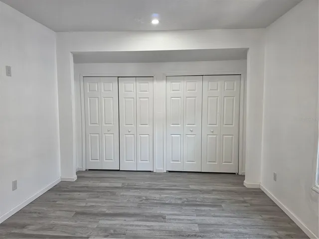 Comfortable primary suite offering a bright walk-in closet with ample lighting and a private en-suite bathroom.