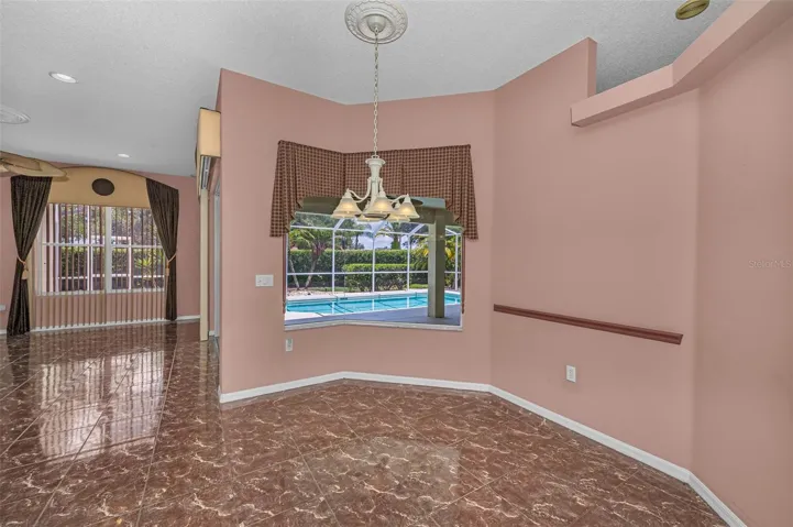 Breakfast area with a beautiful view of pool and landscaped lot.