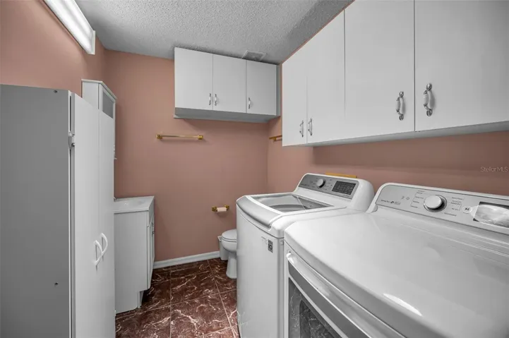 Laundry room with an extra half-bath and cabinets