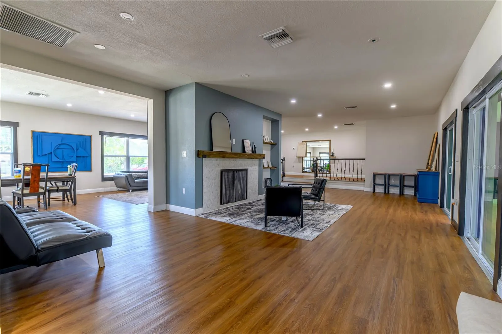 Left to Right:  Dining/Living Room, Fireplace Sitting Area/2nd Living Room Space, (2) Step up Platform to Primary Bedroom on Left & Bedroom 2, 3, & Main Bathroom to the Right, and Sliding Glass Doors leading to the Florida Room