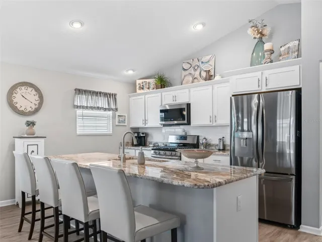 Spacious kitchen with expansive counter space and bar seating.