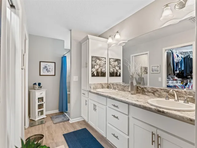 Enjoy spa-like comfort in the en suite bath complete with a tiled Roman shower, elegant granite vanity, and dual sinks.
