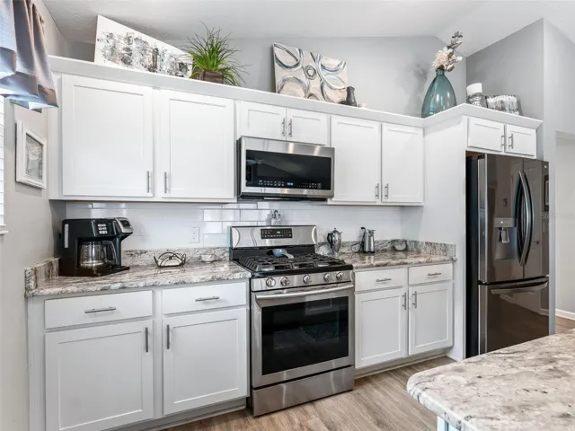 Beautiful kitchen features granite countertops, abundant prep space.