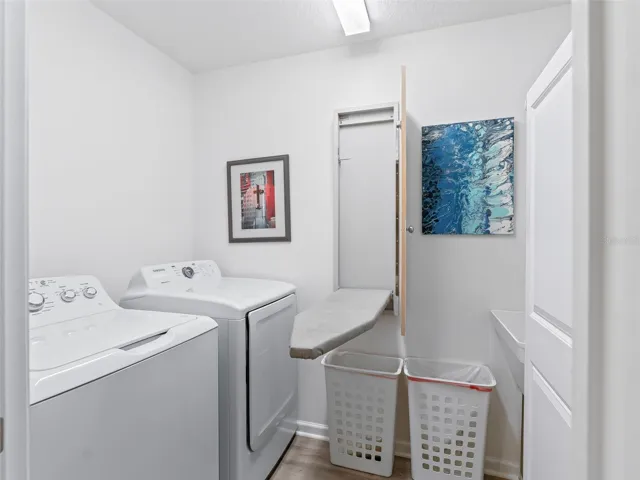 Laundry room feature built-in ironing board, and spacious cabinet for extra storage.