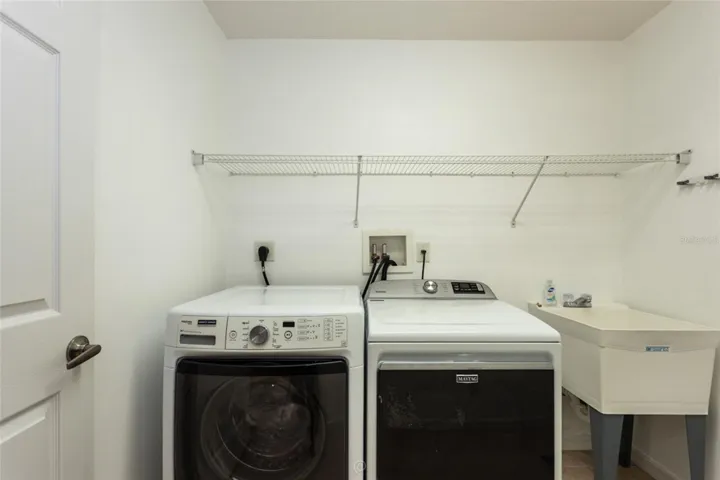 Laundry room with sink.  Washer and dryer convey.