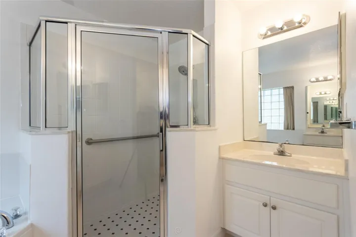 Large tiled shower with a second sink.