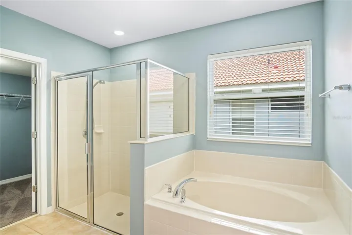 Soak in the tub or enjoy a refreshing shower in the downstairs primary suite with a walk in closet