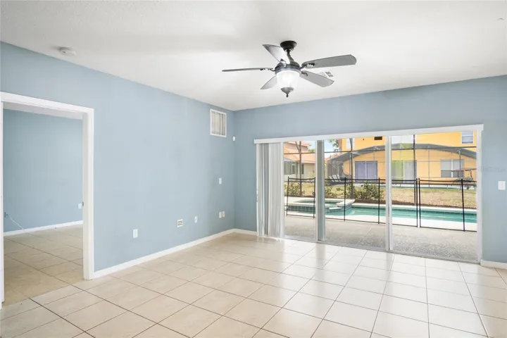 Living room with triple sliders allowing a beautiful pool view
