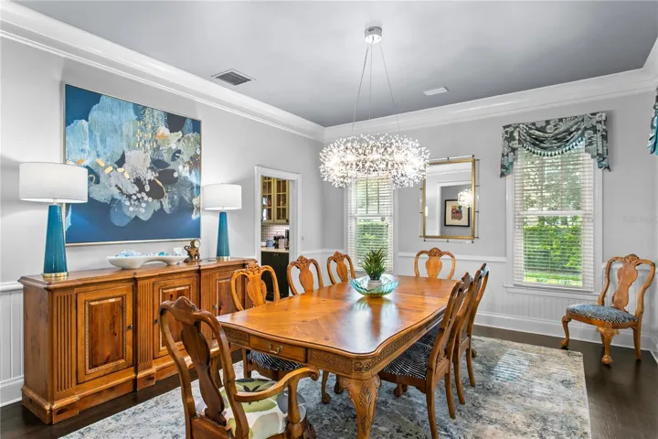 Elegant wainscoting and crown molding adds timeless charm to the formal dining room, ideal for gatherings and holiday meals.
