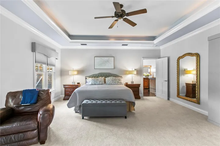The spacious primary bedroom features an elegant tray ceiling and a relaxing atmosphere.