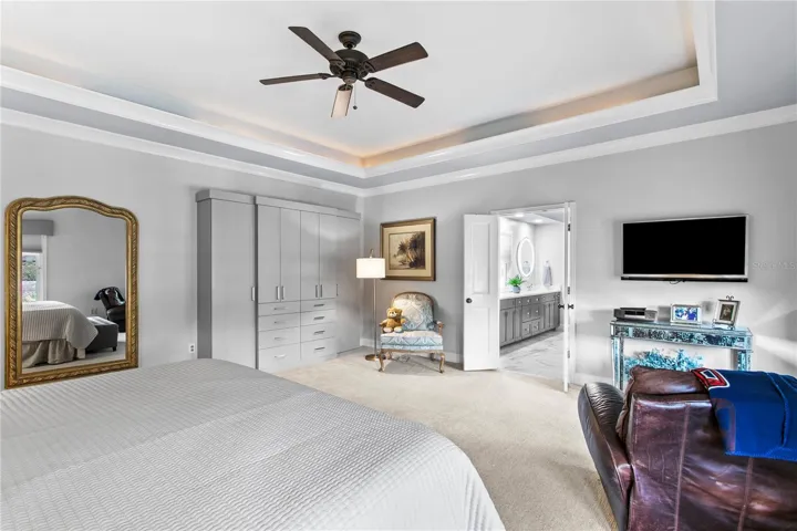 The spacious primary suite features custom cabinetry for added clothing storage and organization.