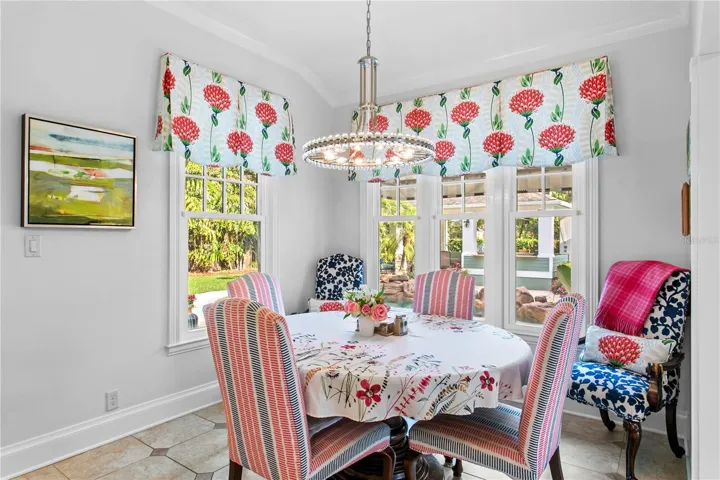 The kitchen space features a casual dining area overlooking the beautiful backyard.