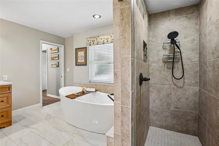 Primary Bathroom with marble floors, free standing tub, 2 large vanities and a walk in shower