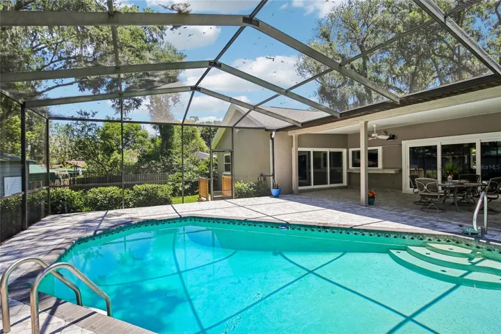 View of pool, pavers and backyard